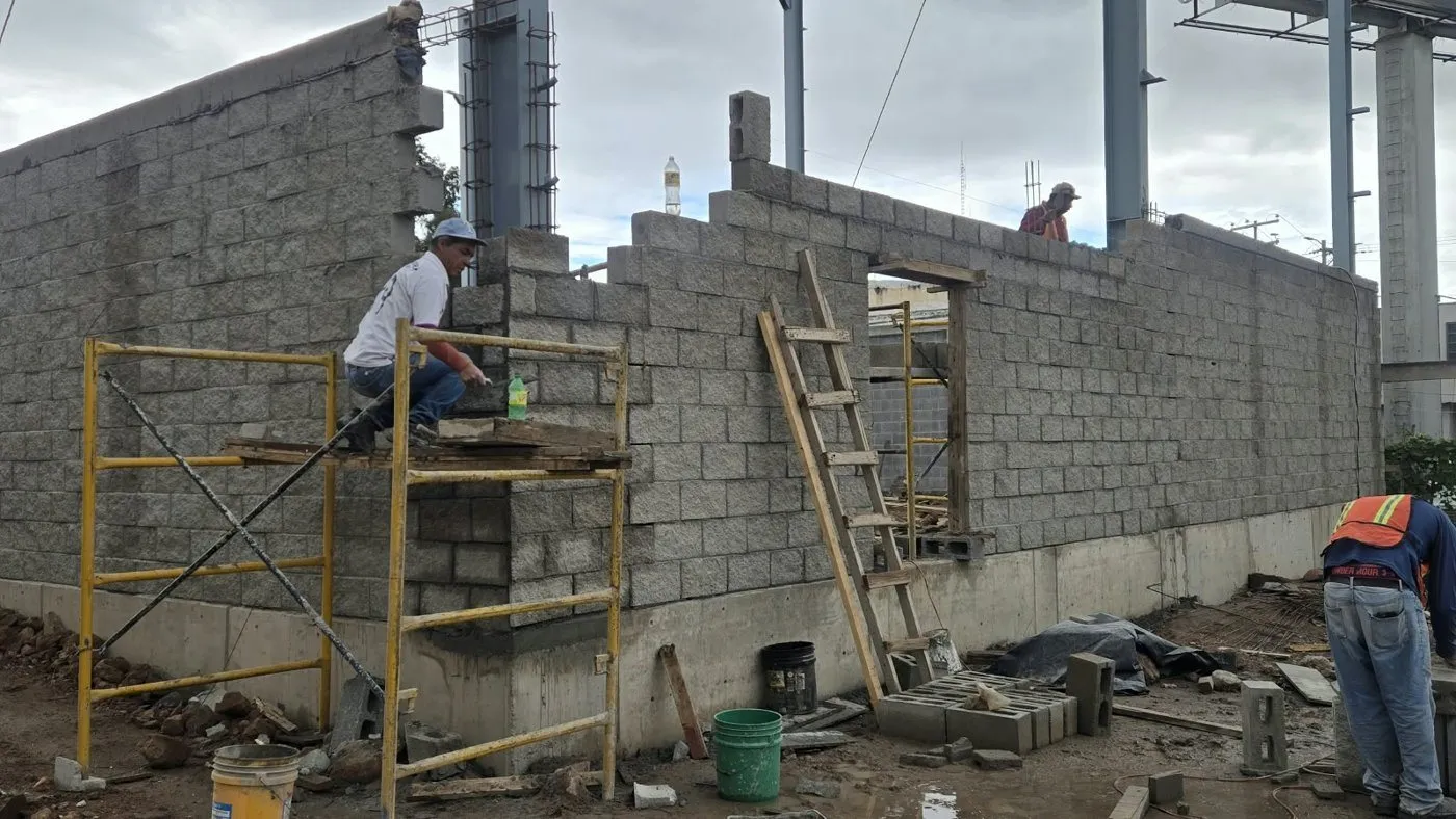 Albañiles colocando block sobre el andamio