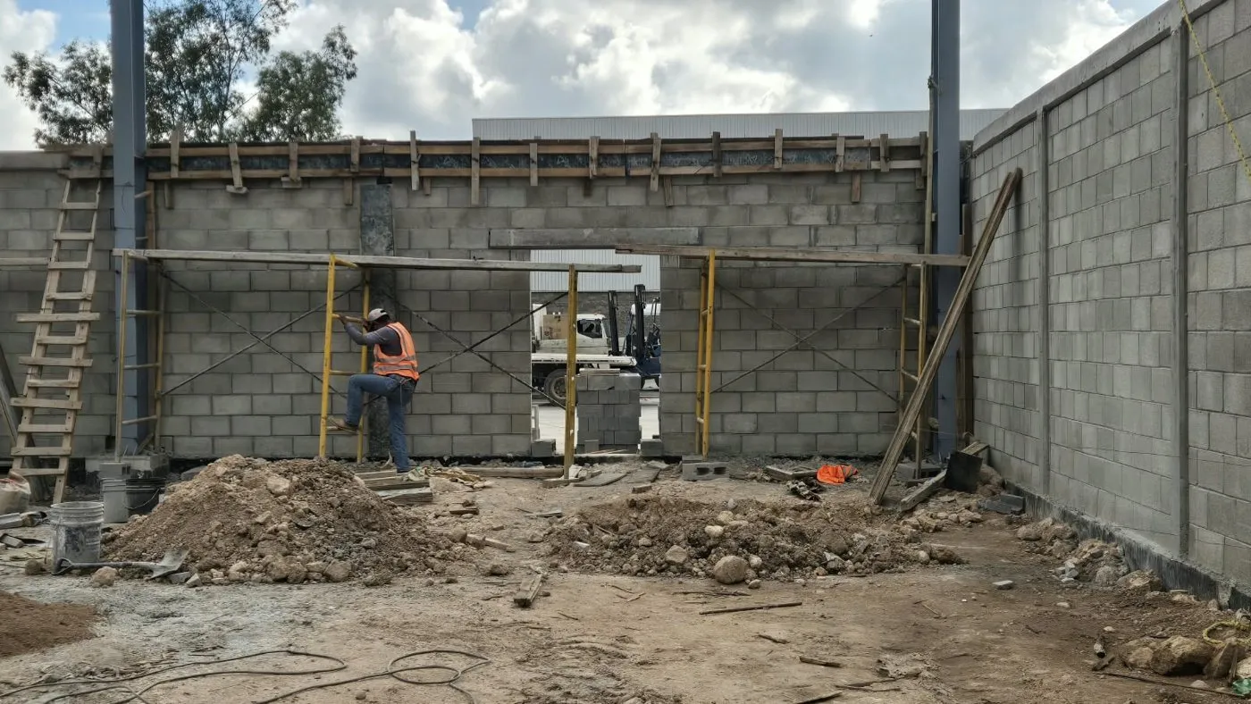 Cuadrilla levantando el muro de block cara de piedra con andamios