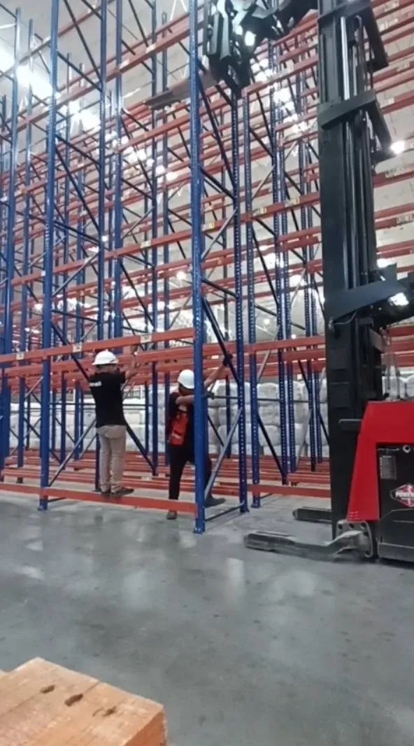 Dos instaladores de ML Racks ajustando vigas en un pasillo de rack selectivo